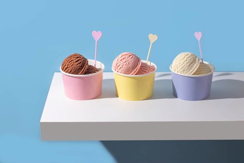 A modern ice cream composition with chocolate, strawberry, and vanilla scoops. The clean background