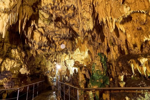 Illuminated cave landscape with numerous stalactites and a path, stalactite cave, Diros Cave,