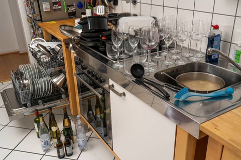 Kitchen after a big dinner, cooking party, dishwasher, full, with cleaned dishes, dirty glasses,