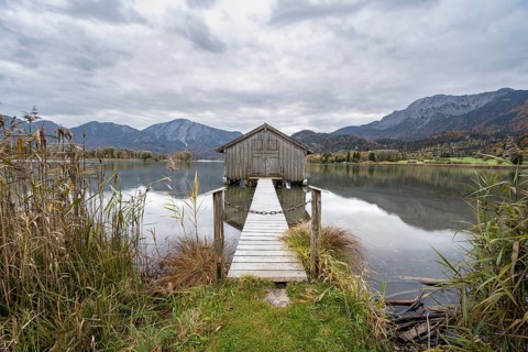 Boathouse in the lake, Lake Kochel in autumn with reflection, Upper Bavaria, Bavaria, Germany