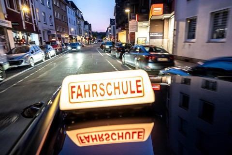 Symbolic picture of driving school, evening trip in the city center, urban traffic
