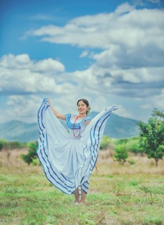 Woman wearing traditional Nicaraguan folk costume in a field. Smiling girl in national folk costume