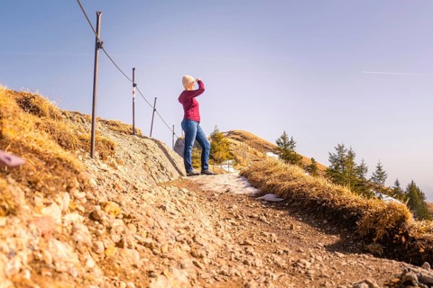 Woman standing on a rocky path with a wide view over the mountain landscape, Hochgrat Mountains,
