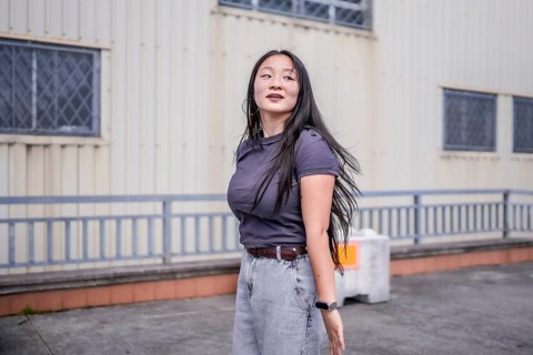 Three quarter length photo of a concentrated female asian young K-pop dancer performing a