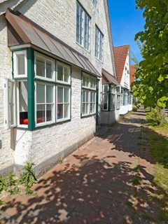 Historic row of houses with bay windows in Lange Strasse, gabled houses whitewashed, footpath,
