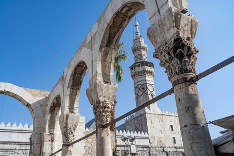 A minaret of the Umayyad Mosque, seen through the arch of the Temple of Jupiter at the entrance to