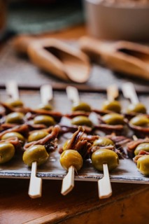 Elegant skewers laden with green olives and anchovies showcase a perfect Mediterranean fusion.