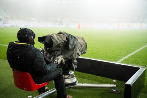 Cameraman next to the playing field during soccer match in Lubin, Poland