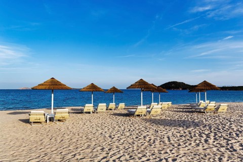 Straw umbrellas, empty sunbeds overlooking the Mediterranean Sea, beach club, Liscia Ruja, sandy