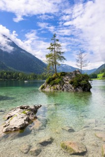 Hintersee near Ramsau with clear green water, surrounded by forests and mountains under a cloudy