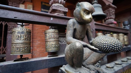 Bronze statue of a monkey with prayer wheels in a traditional Nepalese temple, Kathmandu, Nepal