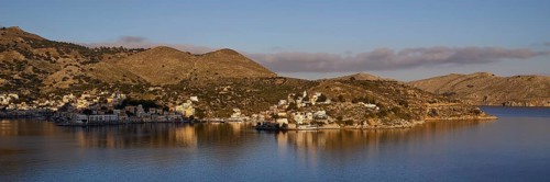 Island view with rolling hills and calm water, blue sky with scattered clouds, Symi Town, Symi,