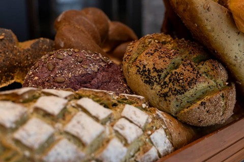 A variety of artisanal breads showcased in a basket. The display features different textures and