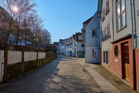 Sunny street with shadows cast by trees and adjacent houses in a quiet area, Am Schlossgraben,