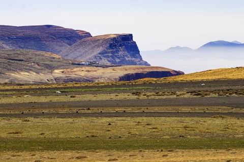Vast volcanic landscape with flat plains, plateaus and a clear sky in the background, Lanzarote,