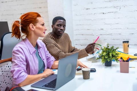 Multi-ethnic coworkers in a meeting room discussing and working together