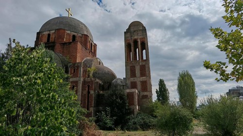 An old church, Christ the Redeemer Cathedral, ruin with domes and a brick bell tower surrounded by