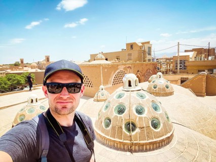 Young caucasian male tourist take selfie on famous bathhouse rooftop in poplar travel destination,