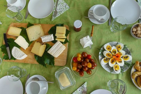 Breakfast table, breakfast, cold buffet, tomatoes in glass bowl, cheese board, wooden board, sliced