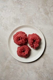 Three mounds of freshly ground beef presented on a white ceramic plate. The meat's rich red color