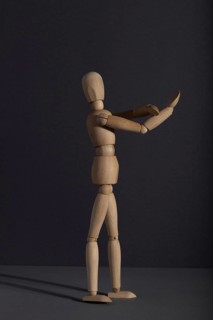 Wooden mannequin shows obscene gesture fuck off with hands on gray background. protest, riot,