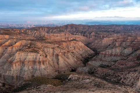 Sunrise, wide hilly desert landscape with dry vegetation, Gorafe desert, semi-desert, Granada,