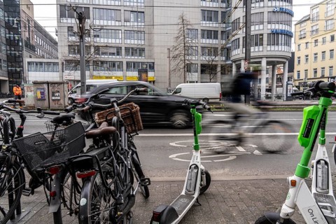 Cycling in the city centre, here at Neumarkt in Cologne, parked bikes and e-scooters at the