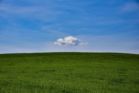 White cloud in the blue sky above a meadow in Bavaria, Germany