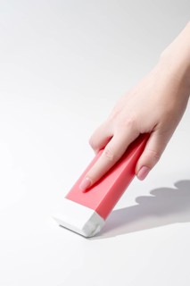 Close up of a hand holding a roll on waxing cartridge designed for easy and effective hair removal.