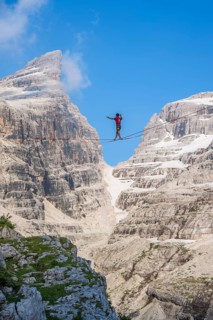 Slackliner in the mountains, mountain peaks of the Brenta Mountains, at Refugio Francis Fox