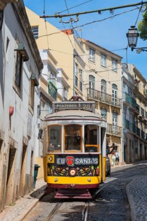Yellow tram on narrow street lined with historic buildings, Tram, Line 28, Carros eléctricos de