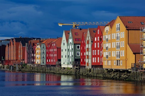 Colourful wooden houses reflected in the blue water, traditional Nordic architecture on the