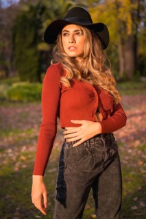 Lifestyle, portrait of a caucasian girl in a black hat at sunset in a green park