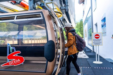 Tourists boarding a cable car in the italian dolomites, ready to ascend to the seceda peaks for