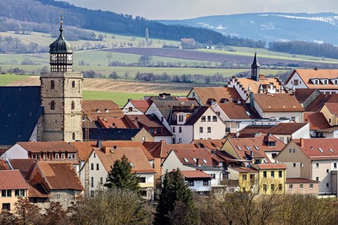 City view with historic tower, red roofs and rolling hills in the background, the skyline of Geisa