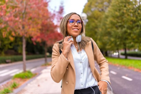 Frontal portrait of a latin cool businesswoman with headphones in the city