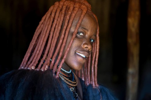 Young Himba woman in her hut, Ohandungu, Kunene region, Kaokoveld, Namibia