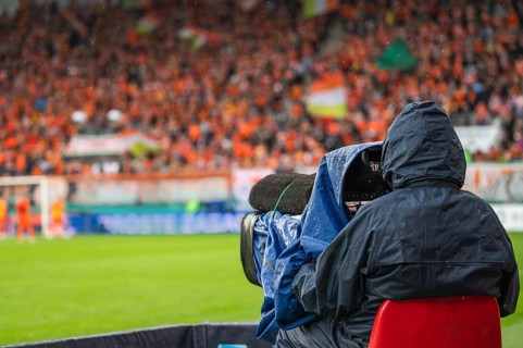 Cameraman near playing field during soccer match in Lubin, Poland