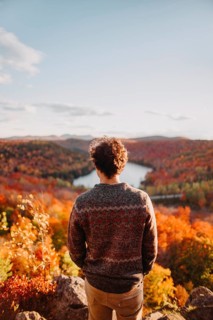 A man enjoys the stunning autumn scenery in Quebec, Canada, as colorful foliage blankets the