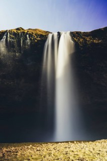 A breathtaking view of a majestic Seljalandsfoss waterfall cascading over a rugged cliff in Iceland