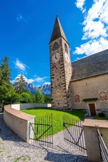 Open iron gate leading to the st. Magdalena church with the odle mountains rising in the background