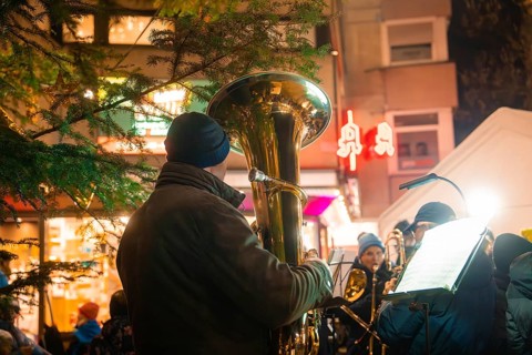 Musician with tuba plays at a Christmas market with night illumination, Lichternacht Fest, Nagold,
