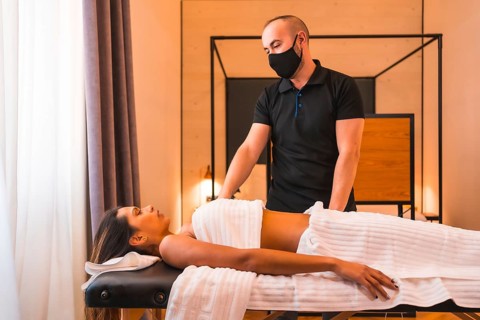Massage at home, a young man performing a massage at the client's home, a little before explaining
