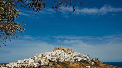 A village with white houses on a hill under a fortress, blue sky, Querini Castle, Chora, Astypalea,