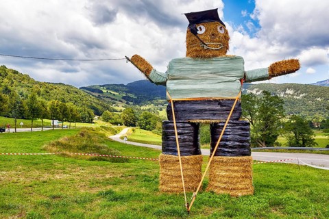 Funny straw puppet made of straw bales, figure, man smoking a pipe, Savoie, Auvergne-Rhone-Alpes,
