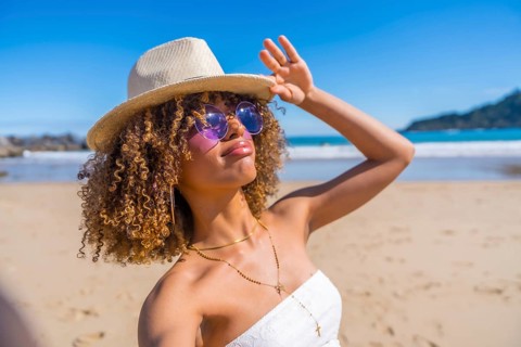 Personal perspective of a distracted latin beauty woman grimacing while taking selfie on the beach
