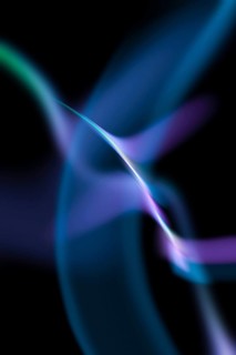 Abstract image featuring flowing, wavy light patterns in blue and purple against a dark background,