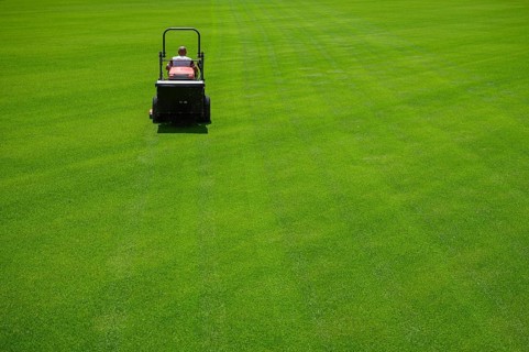 Mowing grass at the football stadium in Lubin, Poland