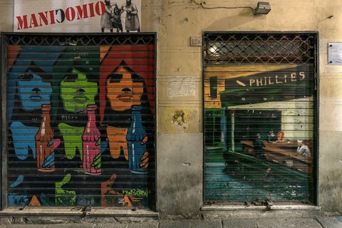 Paintings on closed shop blinds in the old town centre, Genoa, Italy