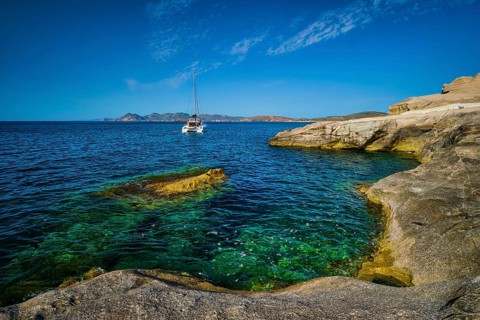Yacht boat in Aegean sea at white rocks of Sarakiniko Beach, Milos island, Greece
